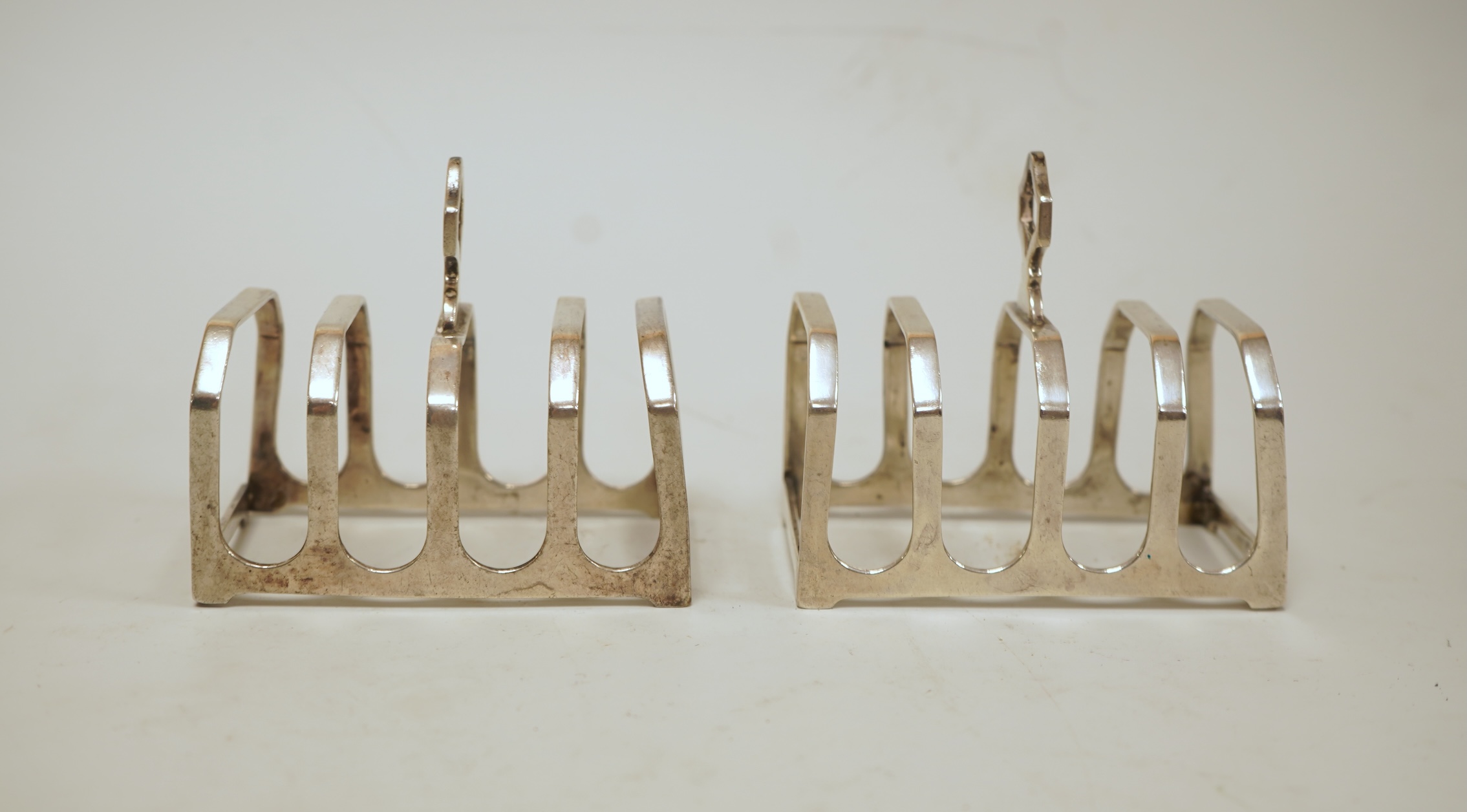 A pair of small George V silver five bar toast racks, Adie Brothers, Birmingham, 1930, length 76mm, together with six assorted silver condiments.